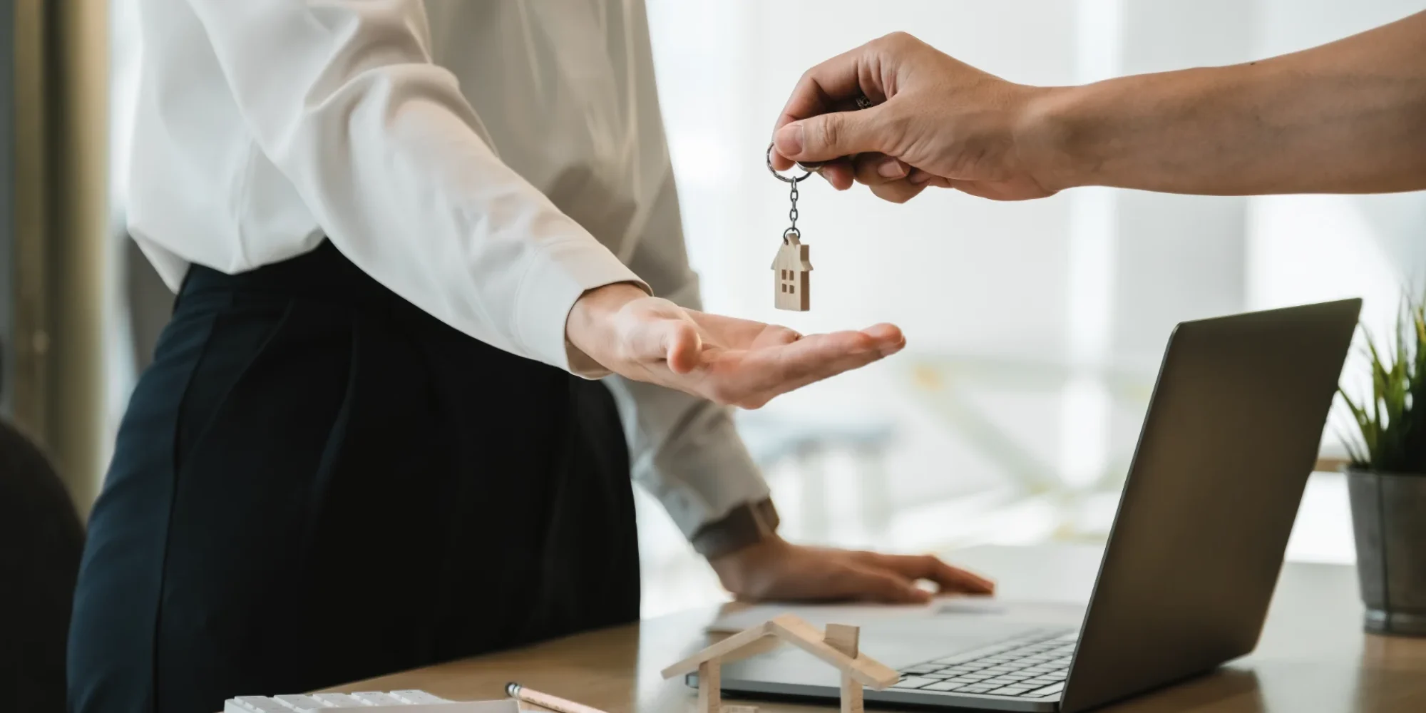 close-up-view-hand-property-realtor-landlord-giving-key-house-buyer-tenant-modern-office