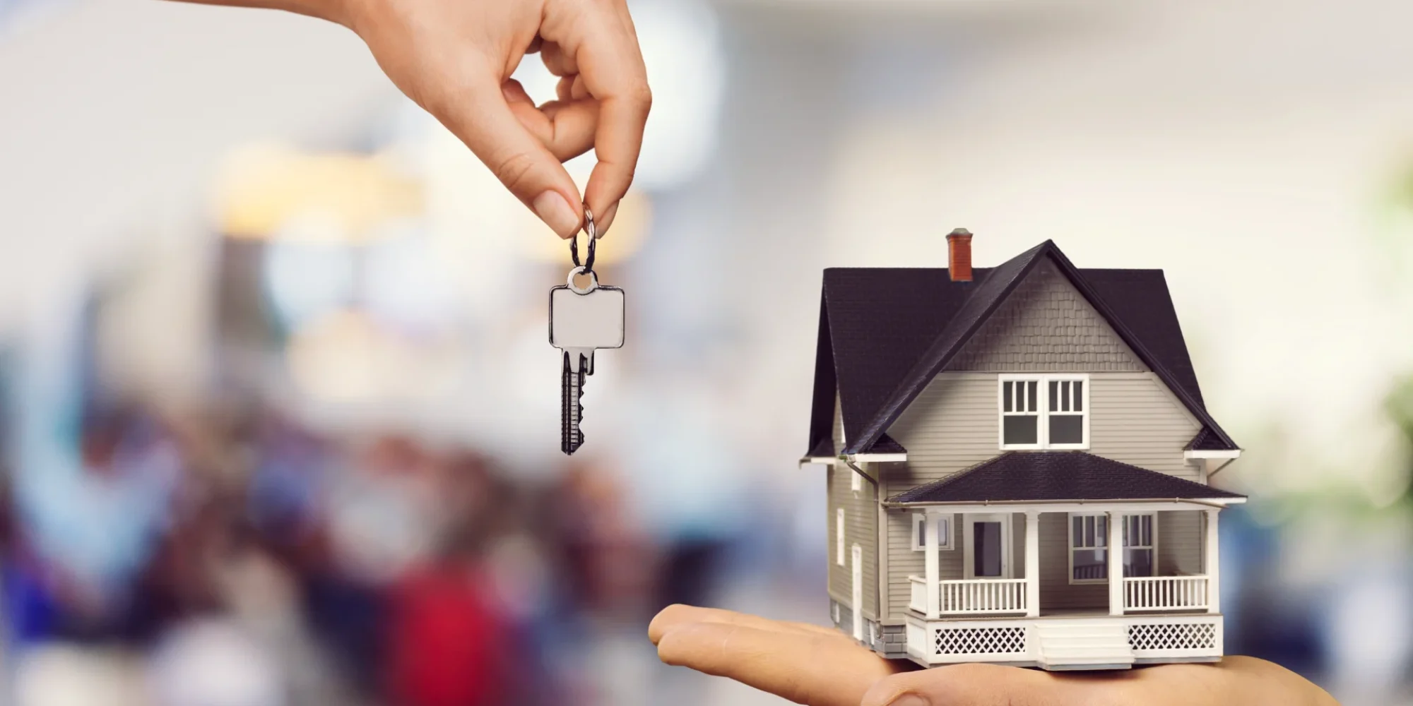 hand-giving-metal-house-keys-mini-house